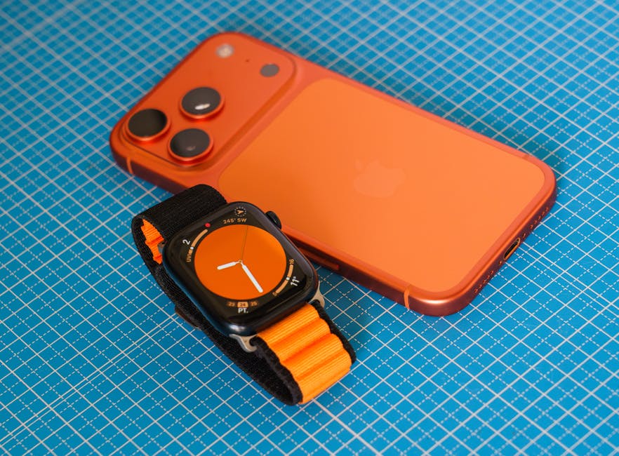 A vibrant orange smartphone and smartwatch with matching features on a blue grid background, highlighting modern technology.