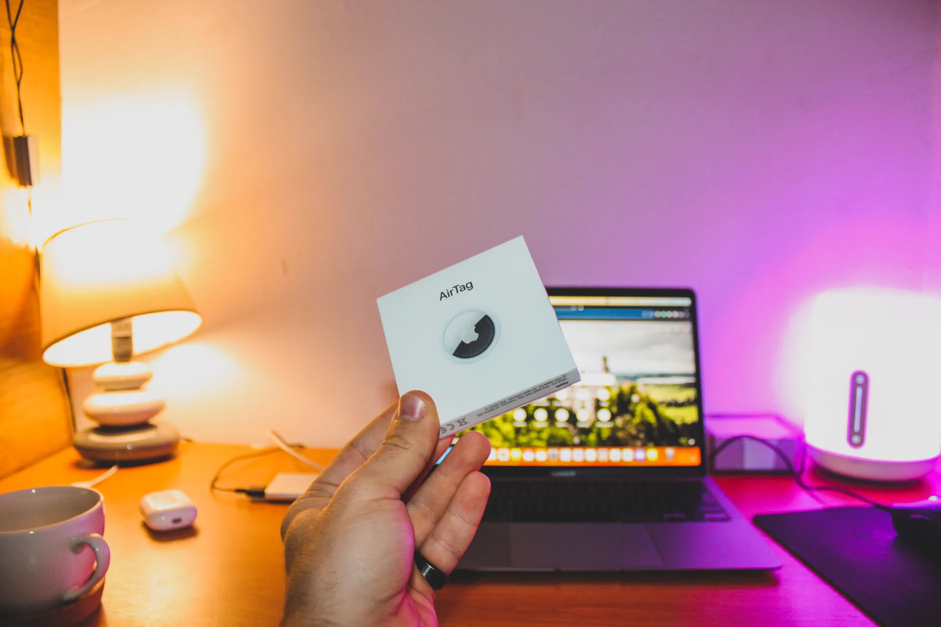 Hero image of Clean official or press product shot of the Apple AirTag on a neutral background, showing the white circular disc design clearly