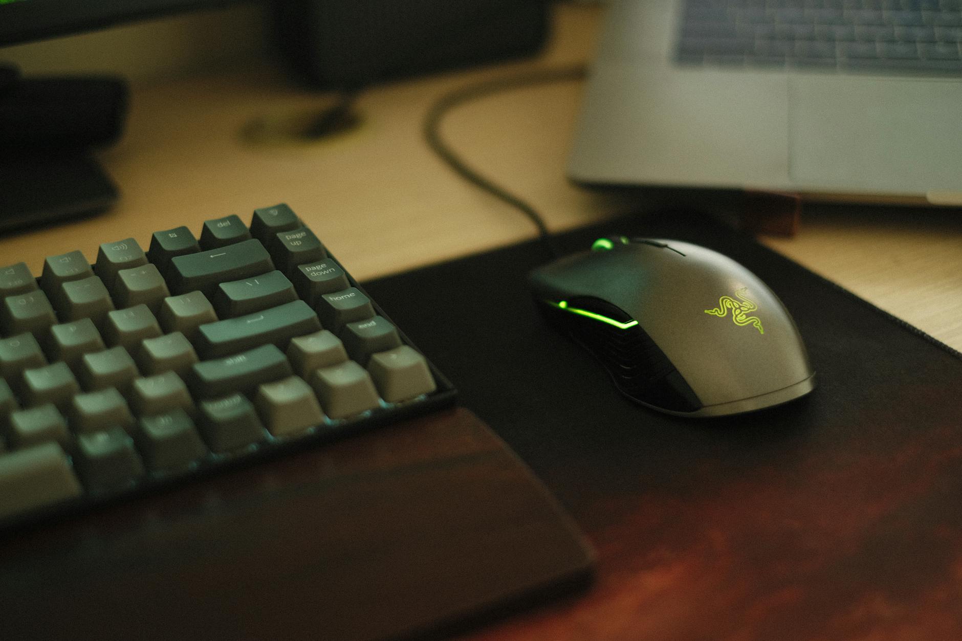 Product Spotlight image of Close-up or hands-on photo of the Razer DeathAdder Essential mouse being held or resting on a mousepad, clearly showing the Razer branding and ergonomic shape
