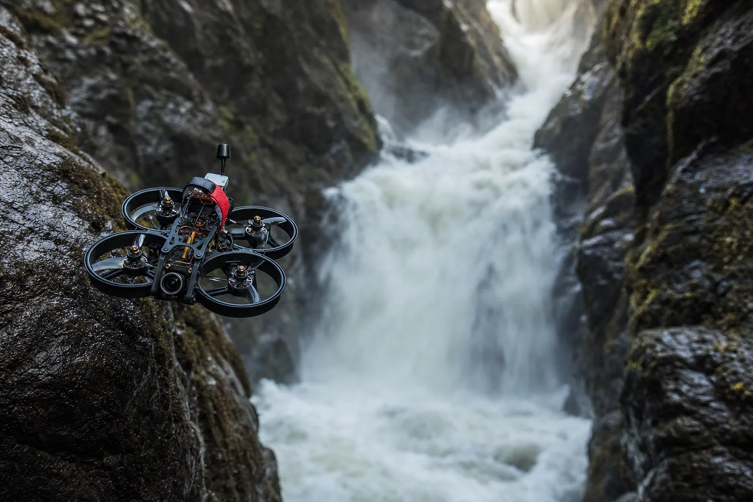 FPV drone diving along a waterfall in dramatic light