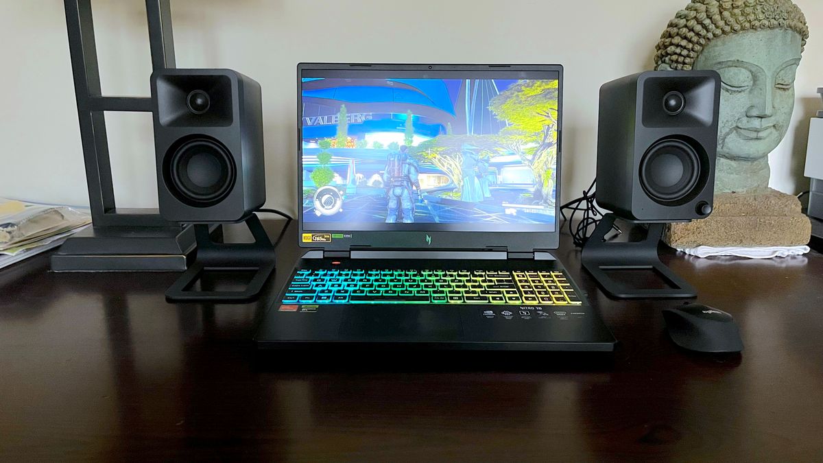 In Use image of Person actively using a 2026 gaming laptop, hands on keyboard, screen clearly visible showing a game or desktop, real-world setting