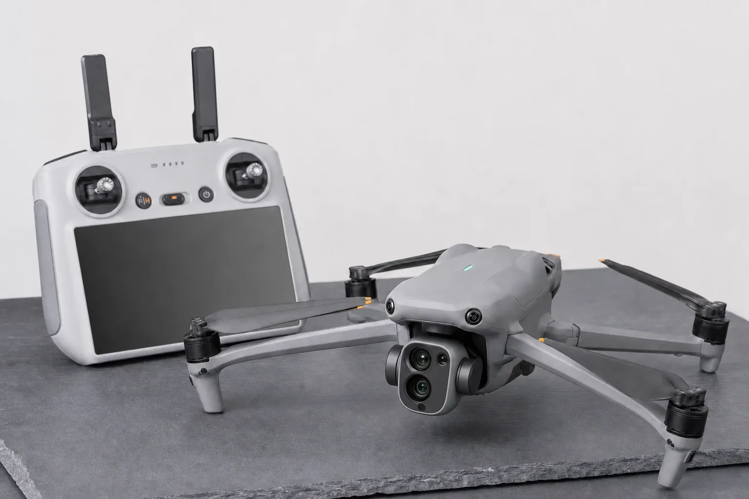 Concept image of a DJI Air-class drone folded beside a screen remote controller