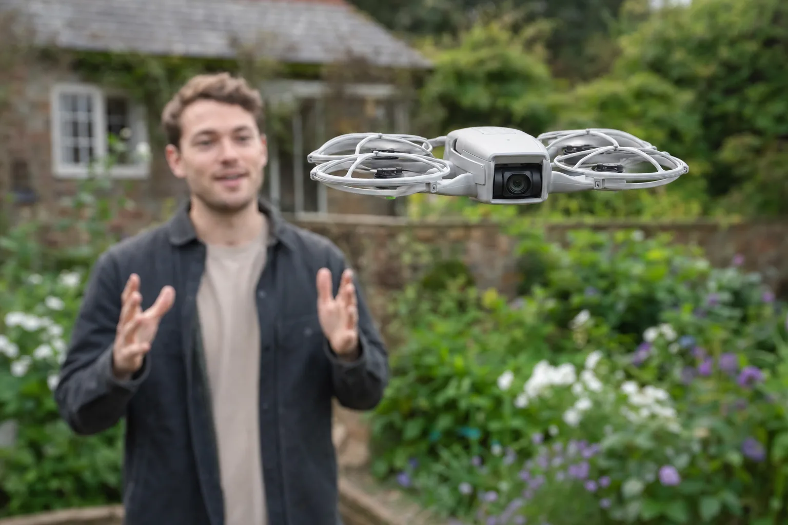 DJI Flip hovering at head height filming a person speaking to camera in a garden