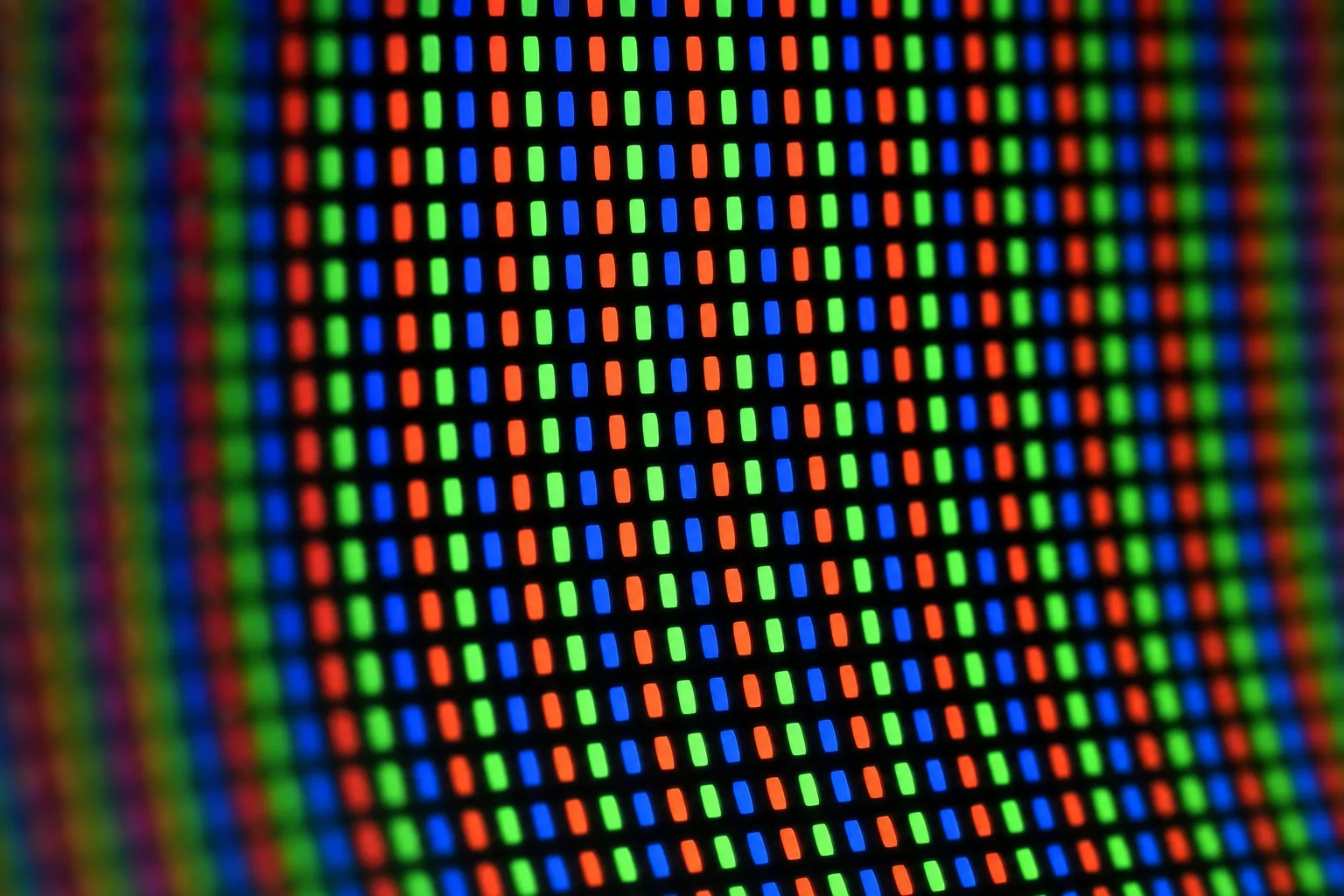 Extreme close-up of an OLED television panel showing individual glowing red, green and blue sub-pixels