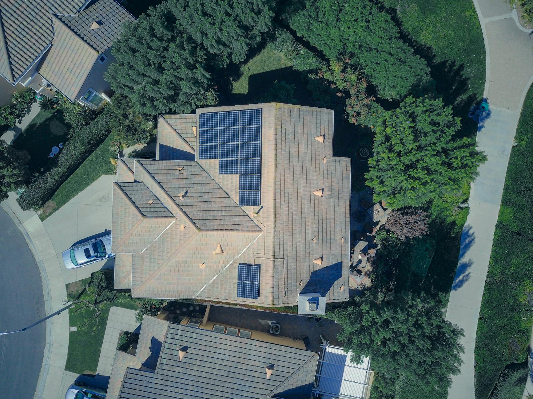 Technology image of Homeowner using a tablet or smartphone to monitor solar energy output via a solar company app, in use real-world photo